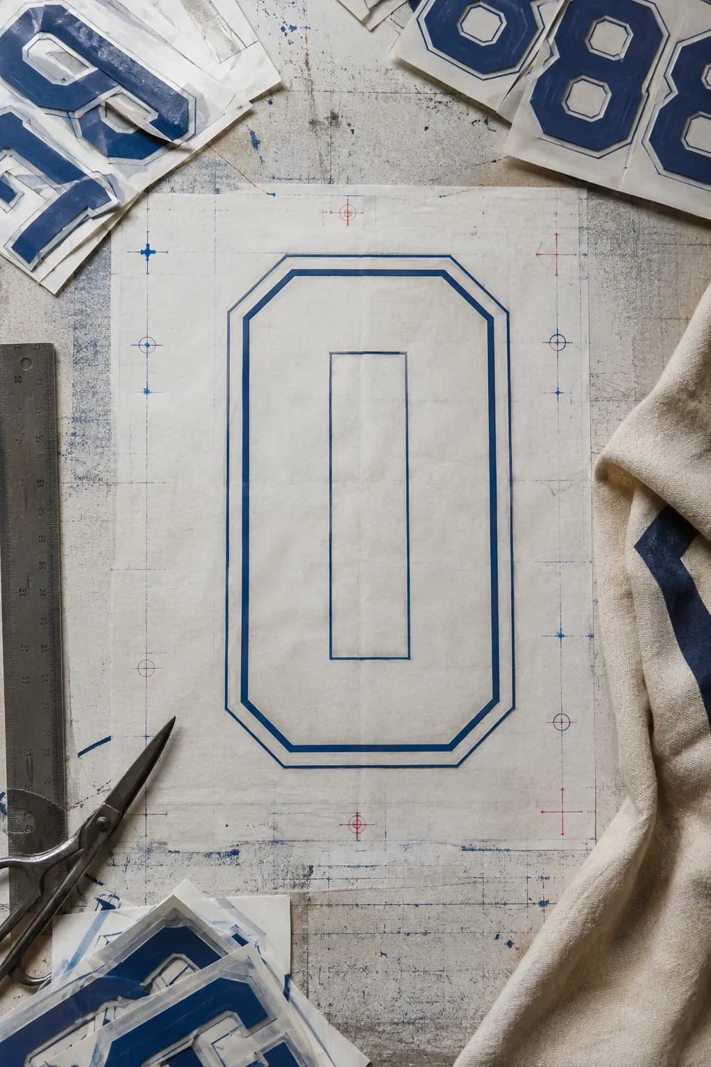 Unbranded football shirt transfer numerals and tools on a print workshop table